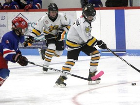 Marty Vanreenen of the Sarnia Jr. Sting minor peewee MD hockey team protects the puck from Ian MacDonald of the Belmont Rangers with Sting teammate Jeff Morningstar following the play. The Rangers defeated the Sting 9-1 in this C division regional Silver Stick game in Watford Saturday afternoon and went on to capture the championship on Sunday. (TERRY BRIDGE, The Observer)