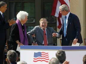 Former U.S. President  George H.W. Bush (2R) is helped up by his son, former President George W. Bush, (R) at the dedication for the George W. Bush Presidential Center on the campus of Southern Methodist University in Dallas, Texas April 25, 2013. President Barack Obama (L) and former first lady Barbara Bush (2L) are seen. (REUTERS/Mike Stone)