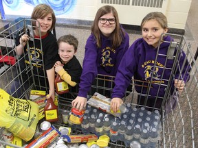Rideau Heights Public School students Ty Everett, Parker Everett, Madison Gingrich and Taryn Grillet look through the collection bin holding the food donated so far during a food drive for the Partners in Mission Food Bank. (Michael Lea/The Whig-Standard)