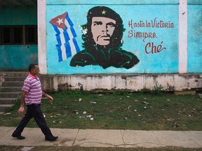A man walks past near an image of revolutionary hero Ernesto "Che" Guevara in Havana December 27, 2014. (REUTERS/Stringer)