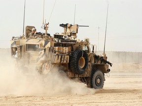 A U.S. armoured vehicle patrols at the site of a suicide attack on a NATO base in Zhari, west of Kandahar province, January 20, 2014. REUTERS/Ahmad Nadeem/Files