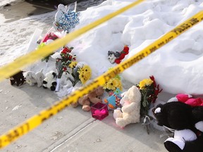 A memorial has begun to grow on Dec. 31, 2014, in front of a home in Edmonton's north end where the bodies of seven people, including two young children, were found a day earlier. DAVE LAZZARINO/EDMONTON SUN