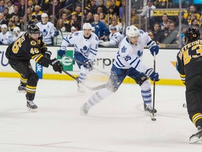Leafs centre Mike Santorelli takes a shot while being defended by two Bruins Wednesday night in Boston. (USA TODAY SPORTS)
