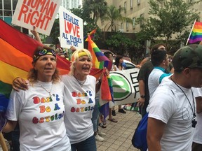 Same-sex marriage supporters Barbara Lawrence (L), 49, and Kimmy Denny, 45, chant outside the Miami-Dade County courthouse following a hearing seeking to strike down the state's de facto ban on gay marriage and order it to recognize same-sex marriage, in Miami, Florida July 2, 2014.  Lawyers representing a half dozen same-sex couples suing Miami-Dade County for the right to marry say Florida should follow the precedent set by the U.S. Supreme Court in a decision last year that struck down parts of the Defense of Marriage Act.  REUTERS/Zachary Fagenson
