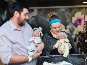 Joushua Garby (L) and his wife Caitlin Garby (R) hold up their newborn twins William (L) and Clare (R) at the Ottawa Civic Hospital on Thursday, January 1, 2015. William and Clare are the first twins of 2015 to be born in Ottawa. Matthew Usherwood/Ottawa Sun