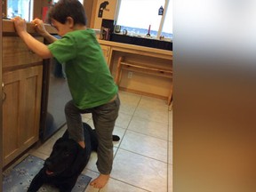 A picture of Sarah Palin's son using the family dog as a "stepping stone" was posted to the former politician's Facebook page on January 1, 2015. (Via Sarah Palin on Facebook)