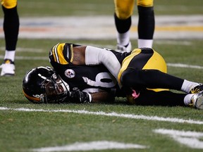 Le'Veon Bell #26 of the Pittsburgh Steelers is injured after being hit by Reggie Nelson #20 of the Cincinnati Bengals during the third quarter at Heinz Field on December 28, 2014 in Pittsburgh, Pennsylvania.   (Gregory Shamus/Getty Images/AFP)