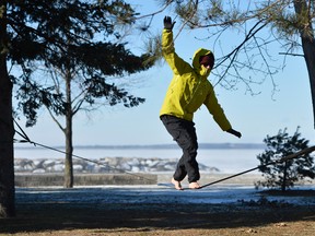 Jared Sanders enjoys the sunny weather while slacklining at Britannia Beach in Ottawa on Friday, January 2, 2015. Matthew Usherwood/Ottawa Sun