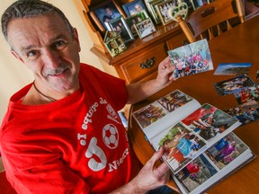 Retired Pickering Fire Platoon Chief Bruce Compton, 61, shown in his home on Jan. 2, 2015 going over photos from his missions in Nicaragua. (Dave Thomas/Toronto Sun)
