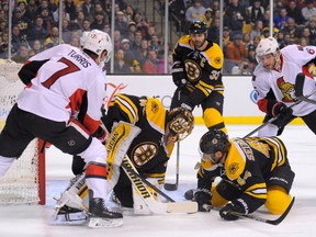 Jan 3, 2015; Boston, MA, USA; Boston Bruins goalie Tuukka Rask (40) ties up the puck in front of Ottawa Senators center Kyle Turris (7) right wing Bobby Ryan (6) and defenseman Dennis Seidenberg (44) during the third period at TD Banknorth Garden. Mandatory Credit: Bob DeChiara-USA TODAY Sports