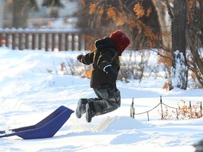 Duties be damned. River Ollivier, 7, takes a break from shovelling the sidewalk in front of the family home on Warsaw Avenue near Stafford Avenue to play in the snow on Sat., Jan. 3, 2015. Kevin King/Winnipeg Sun/QMI Agency on Sat., Jan. 3, 2015.
