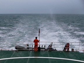 A rescue member stands on the deck of SAR ship KN Purworejo during a search operation for passengers onboard AirAsia flight QZ8501, in Java Sea, Indonesia January 3, 2015. Indonesia search and rescue teams hunting for the wreck of an AirAsia passenger jet have located four large objects in the Java Sea, agency chief Fransiskus Bambang Soelistyo told reporters on Saturday. The Indonesia AirAsia Airbus A320-200 plunged into the Java Sea on Sunday while en route from Indonesia's second-biggest city Surabaya to Singapore with 162 people on board. No survivors have been found. REUTERS/Beawiharta