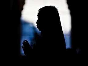 Mourners attend a prayer service for the victims of last week's mass murder at the Truc Lam Monastery in Edmonton, Alta., on Sunday, Jan. 4, 2015. Codie McLachlan/Edmonton Sun/QMI Agency