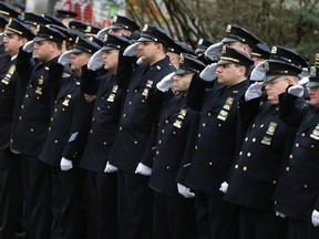Police salute as they stand in formation down 65th street during the funeral service for New York Police Department officer Wenjian Liu in the Brooklyn borough of New York. (REUTERS)