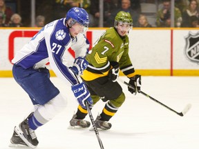 Sudbury Wolves centre Matt Schmalz (27) drives into the North Bay Battalion as Miles Liberati (7) defends during the second period of OHL action at Memorial Gardens, Sunday. Schmalz was held off the scoresheet in a 6-2 Battalion win.