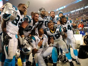 Carolina Panthers quarterback Cam Newton (1) and the Carolina Panthers pose for a picture after beating the Arizona Cardinals in the 2014 NFC Wild Card playoff football game at Bank of America Stadium. (Sam Sharpe-USA TODAY Sports)
