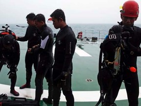 A group of divers prepares their gear on the deck of the Search and Rescue (SAR) ship KN Purworejo during a search operation for passengers onboard AirAsia Flight QZ8501 in the Java Sea January 4, 2015.   REUTERS/Beawiharta