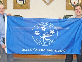 West Perth Mayor Walter McKenzie (left) and Jamie Cottle, Events Coordinator with the Alzheimer Society of Perth County, display the flag that will be flown at Centennial Park for Alzheimer awareness month in January. KRISTINE JEAN/MITCHELL ADVOCATE