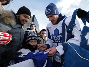 Leafs' Dion Phaneuf  signs some autographs for the fans. The Toronto Maple Leafs practiced outside at the Harry Gairey rink in Toronto on Monday January 5, 2015. Craig Robertson/Toronto Sun/QMI Agency