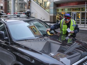 Toronto Police Const. Gord Fowlds tickets a vehicle on Richmond St. on Monday January 5, 2015. (Dave Thomas/Toronto Sun)