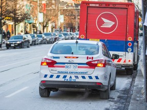 A Canada Post truck was able to drive away before the parking enforcement officer had a chance to put a ticket on the windshield along Queen St. W. during the evening rush hour in downtown Toronto on Monday January 5, 2015. (Ernest Doroszuk/Toronto Sun)