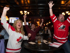 JoAnne Mather, left, Ken LeBlanc, and Andrew Gibson watch the gold medal World Juniors hockey game between Canada and  Russia at The Pint, 8032 - 104 St., in Edmonton Alta., on Monday Jan. 4, 2015. Canada won 5-4 (DAVID BLOOM/Edmonton Sun)