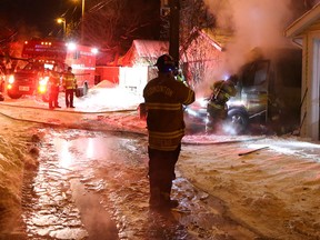 Firefighters work at a home near 109 Avenue and 123 Street, in Edmonton on Monday Jan. 4, 2015. Firefighters were responding to a call about an explosion. (David Bloom/Edmonton Sun/QMI Agency)