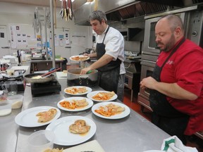 Chefs Claudio Tentenni (left) and Chris Hrynyk plate the cooking class food.