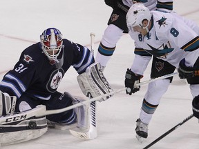 Winnipeg Jets goalie Michael Hutchinson (left) blocks a shot by San Jose Sharks center Joe Pavelski during NHL hockey in Winnipeg, Man. Monday, Jan. 5, 2015.