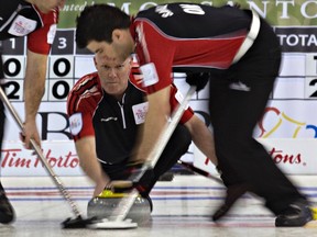 Ontario skip Glenn Howard watches the line of his shot as teammate Craig Savill sweeps during the Canadian Men's Curling Championships in Edmonton March 3, 2013.  (Reuters File)
