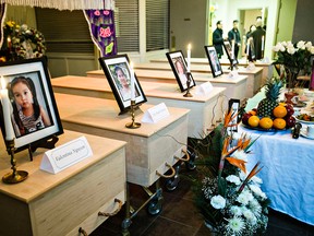 Caskets with photos of victims are seen during the funeral at Howard & McBride Chapel of Chimes for six of the mass killing victims who died last week in Edmonton, Alta., on Tuesday, Jan. 6, 2015. The victims who were honoured include Valentina Nguyen, Ha Thanh Truong, Dau Thi Le, Van Dang Truong, Tien Thuy Truong and Elvis Lam. Codie McLachlan/Edmonton Sun/QMI Agency