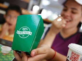 A girl eats deep-fried yucas at a McDonald's restaurant in Caracas January 6, 2015. Venezuelan fast-food lovers are mourning the disappearance of McDonald's golden staple: the french fry. A recent shortage at the U.S. fast food chain comes as socialist Venezuela grapples with shortfalls of basic goods ranging from medicines to flour due to strict currency controls that stymie imports. McDonald's restaurants are coping by replacing the spuds with salad or local fare such as fried yuca or "arepa" corn pancakes - but Golden Arches fans are none too happy about the new meal.  REUTERS/Jorge Silva