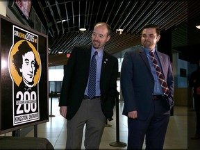 Kingston Mayor Bryan Paterson, left, and Kingston Frontenacs Executive Director of Business Operations Justin Chenier look at a sign bearing the Sir John A Macdonald shoulder patch the Frontenacs will wear on their jerseys for the remainder of the calendar year. (Ian MacAlpine/The Whig-Standard)