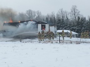 Ottawa fire crews battle a blaze which destroyed a single-family bungalow along Dobson Lane near the village of Richmond on Wednesday morning. (KEATON ROBBINS Ottawa Sun)