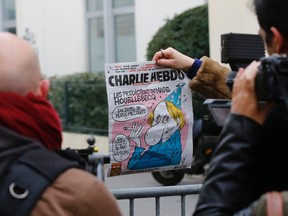 Charlie Hebdo is a small French satirical weekly known for mocking authority, including all forms of religion. Wednesday's cover featured a caricature of well-known French novelist, Michel Houellebecq, who has just published a controversial novel, which imagines France transformed into an Islamic-like state.
Houllebecq is shown in the weekly making predictions for the New Year, saying, “In 2015, I’m going to lose my teeth” and, “In 2022, I will celebrate Ramadan.” The weekly was firebombed in 2011 after mockingly calling itself “Charia Hebdo” -- a play on sharia -- and depicting Mohammad in a front-page cartoon as its "guest editor" saying, “100 lashes if you don’t die of laughter.” ​  (REUTERS/Jacky Naegelen)
