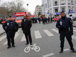 Policemen work at the scene after a shooting at the Paris offices of Charlie Hebdo on January 7, 2015. (REUTERS/Youssef Boudlal)