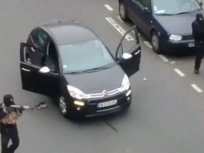 Gunmen flee the offices of French satirical newspaper Charlie Hebdo in Paris, in this still image taken from amateur video shot on January 7, 2015, and obtained by Reuters. (REUTERS/Handout via Reuters TV)