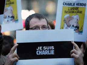 A man holds a placard which reads "I am Charlie" to pay tribute during a gathering at the Place de la Republique in Paris on January 7, 2015, following a shooting by gunmen at the offices of weekly satirical magazine Charlie Hebdo. (REUTERS/Gonzalo Fuentes)