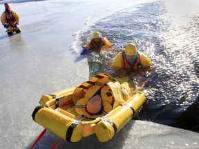 Belleville Fire Department's lead Ice and Water Safety Instructor Don Carter, left, puts these city firefighters through a series of on-ice rescue scenarios on the Bay of Quinte, under the Norris Whitney Bridge, Wednesday morning Jan. 7, 2015. - JEROME LESSARD/THE INTELLIGENCER/QMI AGENCY