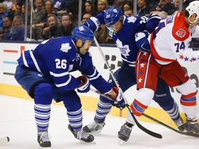 Daniel Winnick and David Booth fight John Carlson for the puck as the Toronto Maple Leafs beat the Washington Capitals at the Air Canada Centre 6-2 on Saturday November 29, 2014. (Stan Behal/Toronto Sun)