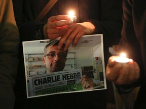 People hold candles as they pay tribute to the victims of a shooting by gunmen at the offices of weekly satirical magazine Charlie Hebdo in Paris, in front of the European Parliament in Brussels January 7, 2015. Gunmen stormed the Paris offices of the weekly satirical magazine Charlie Hebdo, renowned for lampooning radical Islam, killing at least 12 people, including two police officers in the worst militant attack on French soil in recent decades.  REUTERS/Francois Lenoir
