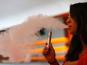 Enthusiast Brandy Tseu uses an electronic cigarette at The Vapor Spot vapor bar in Los Angeles last year. Steinbach is considering banning e-cigarettes from its facilities. (REUTERS FILE PHOTO)