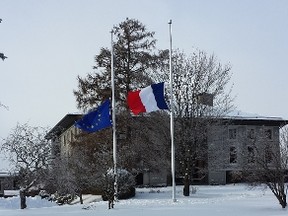 The flags of France, right, and the European Union were lowered to half mast in front of the French embassy in Ottawa Wednesday. Around the world, people were paying their respects to the 12 people killed in an act of terrorism in Paris. Wednesday. (Corey Larocque / Ottawa Sun)