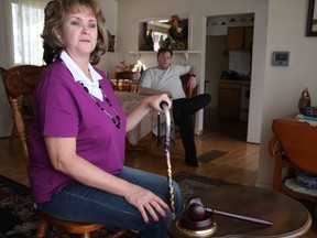 Tonie Farrell sits in her mother’s Orillia home where she now lives because she can’t work after suffering catastrophic injuries from a beating by a police officer. Her son, R.J. Farrell, who bought her a silver plated gavel the says "Not Guilty," looks on. (Tracy McLaughlin/Special to the Toronto Sun)