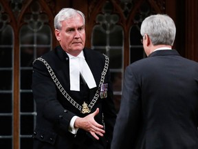 Prime Minister Stephen Harper shakes hands with Sergeant-at-Arms Kevin Vickers in the House of Commons in Ottawa October 23, 2014. Vickers was being thanked for shooting the suspect during a shooting incident Thursday after a gunman killed a soldier and rampaged through parliament before being shot dead. REUTERS/Chris Wattie