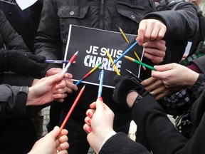 Journalists and other people hold pencils and placards that read "I am Charlie" during a minute of silence for the victims of Wednesday's shooting at the Paris offices of weekly newspaper Charlie Hebdo in Ljubljana January 8, 2015. France began a day of mourning for the 12 journalists and police officers shot dead on Wednesday morning by black-hooded gunmen using Kalashnikov assault rifles.
    REUTERS/Srdjan Zivulovic