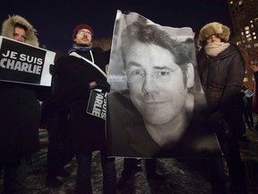 People hold a poster of Bernard Verlhac, a cartoonist known as Tignous, who was killed by gunmen at the offices of weekly satirical magazine Charlie Hebdo in Paris, during a vigil to pay tribute to the victims, in the Manhattan borough of New York, January 7, 2015.
Hooded gunmen stormed the Paris offices of the weekly satirical magazine known for lampooning Islam and other religions, shooting dead at least 12 people, including two police officers, in the worst militant attack on French soil in decades. Sign reads "I am Charlie". REUTERS/Carlo Allegri
