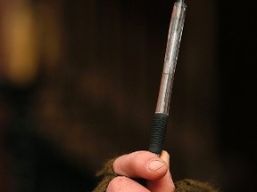 A journalist holds a pen at a service in Londonderry,  for those murdered at Charlie Hebdo magazine offices in Paris Wednesday. Cathal McNaughton/REUTERS