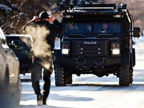 Police tactical units are on scene during a standoff at a home in the area of 106 Street and 55 Avenue in Edmonton, Alta., on Thursday, Jan. 8, 2015. Codie McLachlan/Edmonton Sun