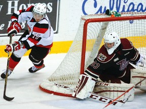 Peterborough Petes' goalie Matthew Mancina covers up against a wraparound against Ottawa 67's Connor Graham  during first period OHL action on Thursday, Jan. 8, 2015 at the Memorial Centre in Peterborough. Clifford Skarstedt/Peterborough Examiner/QMI Agency
